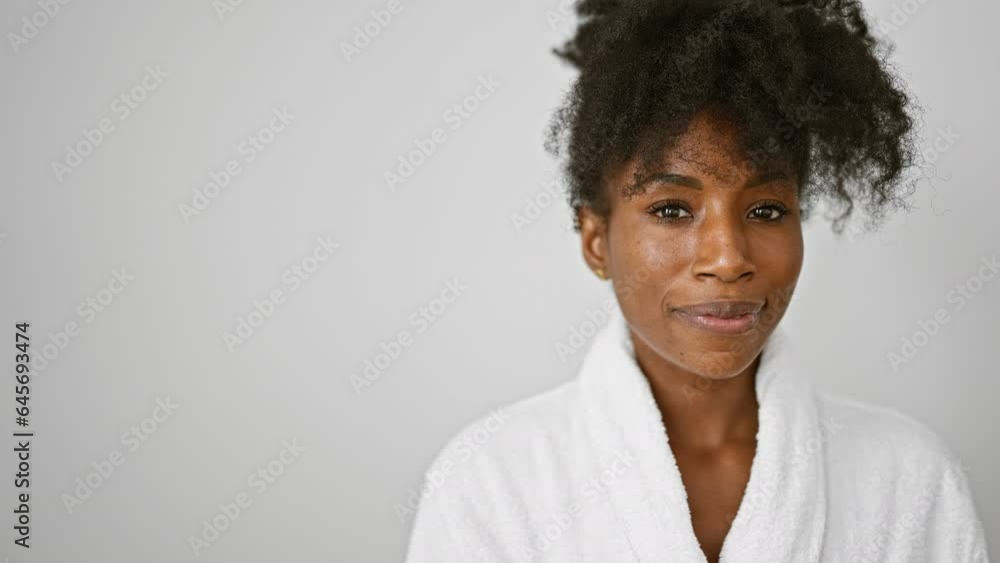 African american woman wearing bathrobe smiling over isolated white background African american woman wearing bathrobe smiling over isolated white background