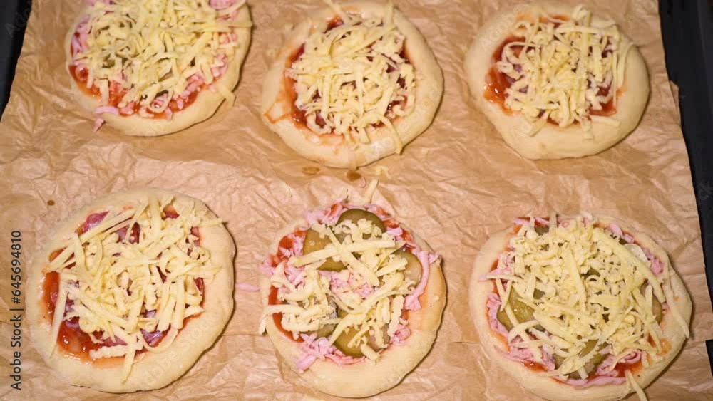 the process of preparing a mini pizza, adding grated cheese the process of preparing a mini pizza, adding grated cheese
