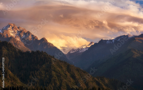 mountains with snowy peaks at sunset. Mountain landscape of the Zailiysky Alatu ridge of the Tien Shan system and in the city of Almaty in Kazakhstan