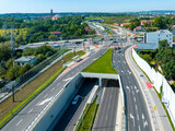 City highway in Krakow, called Trasa Lagiewnicka with multilane road with tunnels, junctions for cars and trams, bicycle lanes, walkways with zebra crossings and acoustic screens. Aerial view