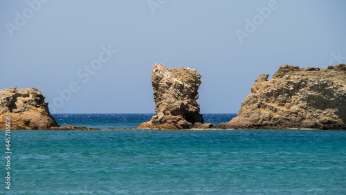 Tranquil Coastline Scenery with Blue Ocean, Sandy Beach, and Rocky Cliff