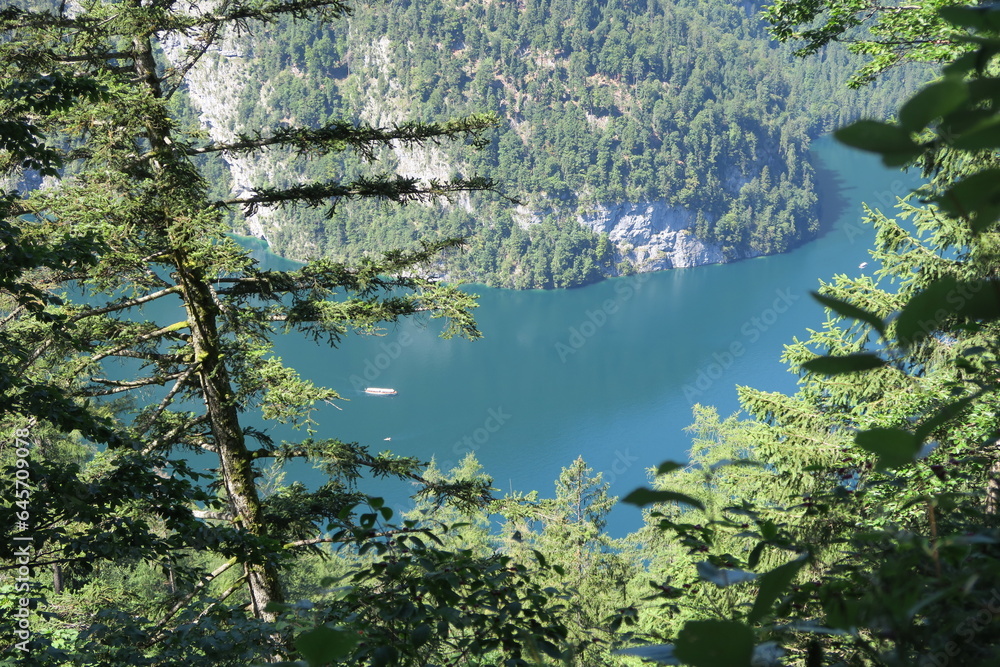 Ein Ausflugsboot fährt auf dem Königssee im Sommer. Blick vom Berg Jenner nahe des Wanderwegs.