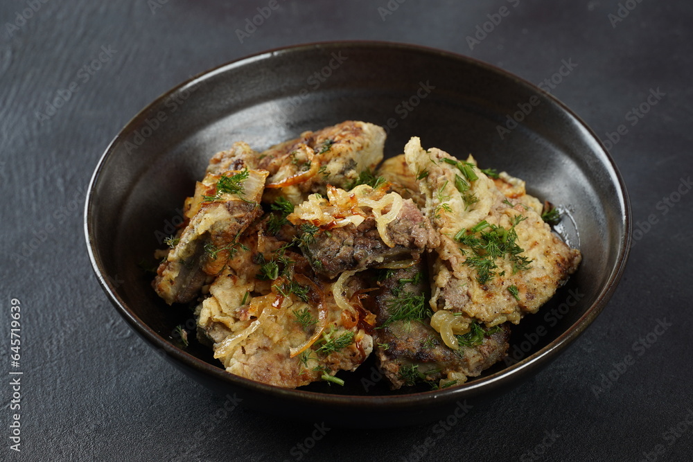 Fried beef liver with fried onions and herbs