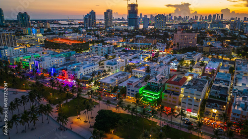 Miami South beach illuminated skyline cityscape at night during sunset drone aerial above ocean road 
