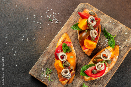 sandwich with marinated anchovies and fresh tomato, olive oil on a wooden board. banner, menu, recipe place for text, top view