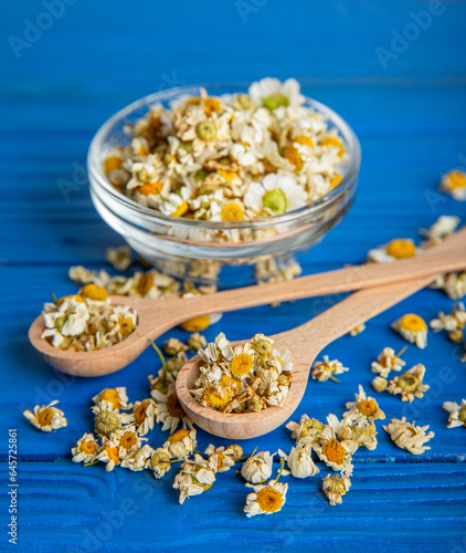 Dry chamomile flowers on a wooden table. Soothing chamomile tea. Herbal drink. flat layout. Space for text.Copy space.Medical prevention and immune concept. Folk alternative medicine.