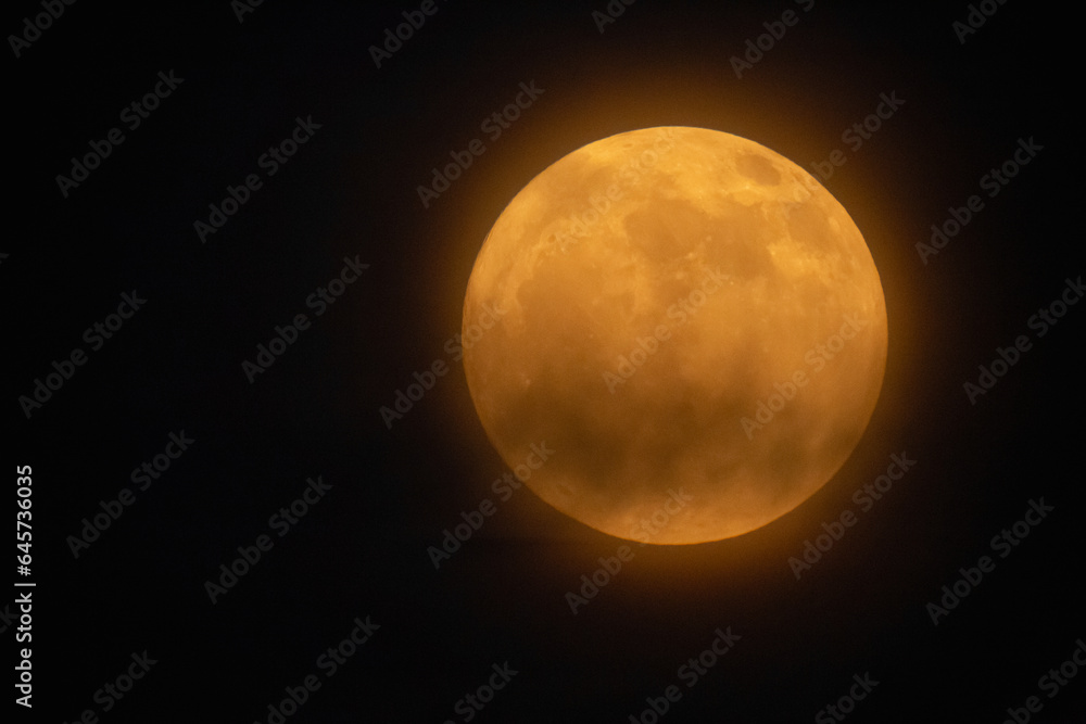 Moon looks orange and you can see the craters. Photography taken with a telescope. Moon looks orange and you can see the craters. Photography taken with a telescope.