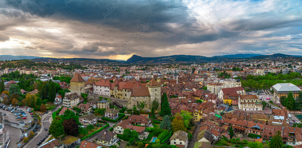 Annecy city center panoramic aerial view over the old town, castle, Thiou river and mountains surrounding the lake. Annecy is known as the Venice of the French Alps