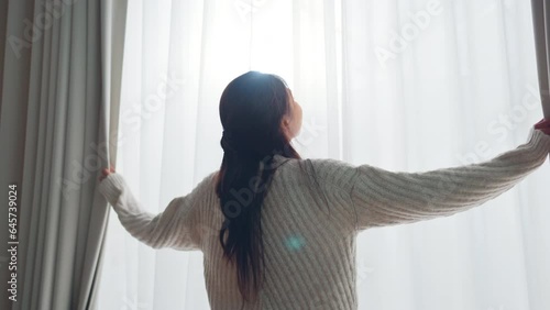Smiling Asian woman opening curtains at morning, Hands pulling window curtain, slow motion