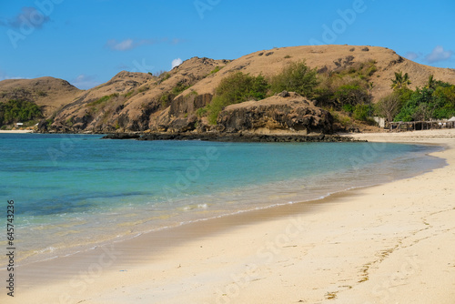 Kuta beach Lombok. Kuta Lombok is a small spread-out town in a beautiful bay lined by a long white sand beach  a beach with blue sky  a beach with sky and white sand  view of the beach in island