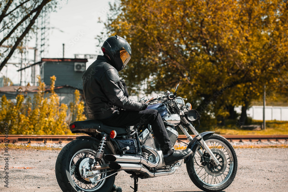 male motorcyclist on a custom chopper motorcycle wearing a helmet.