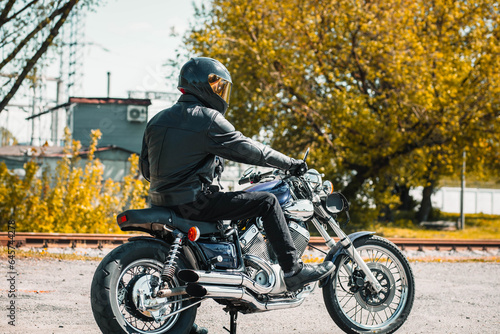 male motorcyclist on a custom chopper motorcycle wearing a helmet. © velimir