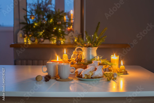 two cups of tea with homemade christmas baked goods on kitchen with christmas...