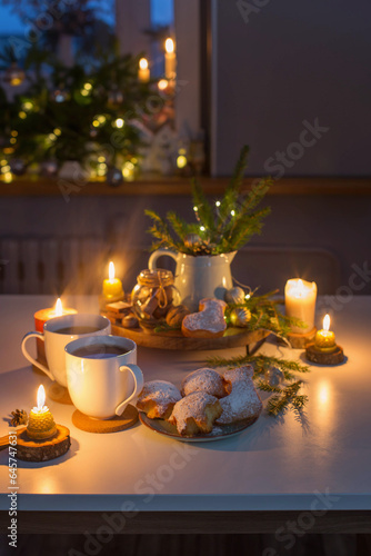 two cups of tea with homemade christmas baked goods on kitchen with christmas...