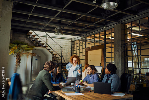 Young and diverse group of designers having a meeting in an office while working in a startup company