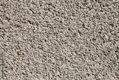 Background small fractions of crushed stone with sand frozen in cement mortar  close-up  uniform texture