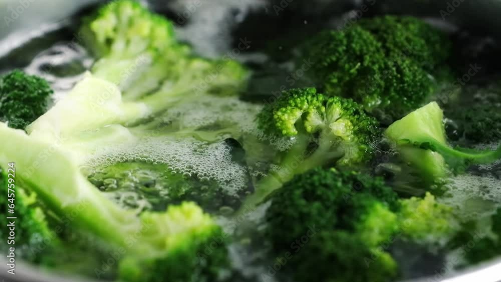 Green broccoli boiling in water closeup. Healthy organic vegetable preparation for vegetarian diet Green broccoli boiling in water closeup. Healthy organic vegetable preparation for vegetarian diet