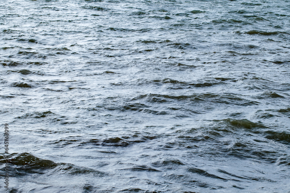 Water surface of the sea with slight waves in cloudy weather close-up