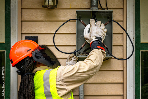 An electrical technician removes the old Power Meter and replaces it with a new Smart Meter at our home in Windsor in Upstate NY.  PPE worn at all times by Worker.