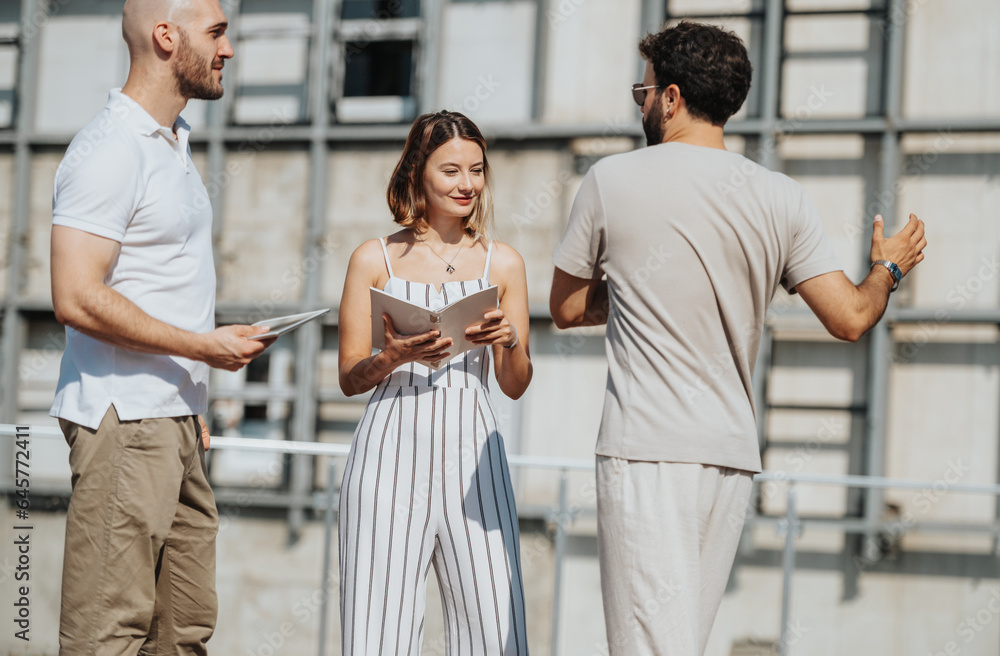 Obraz premium A team of architects and designers discuss a modern building project outdoors, focusing on design, engineering, and collaboration.
