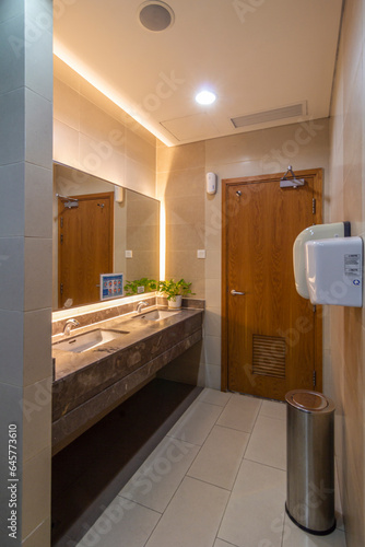 The design is simple, and the lighting provides a warm and inviting ambiance in a restroom located in an office building. 