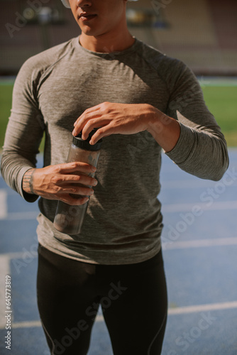 Cool male person closing his bottle of water