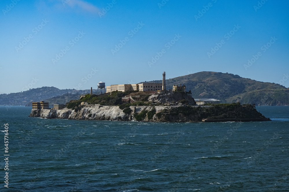 Alcatraz Island in San Francisco Bay seen from ship during Harbor Cruise from SFO tourist landmark travel destination on sunny day with clouds and blue sky