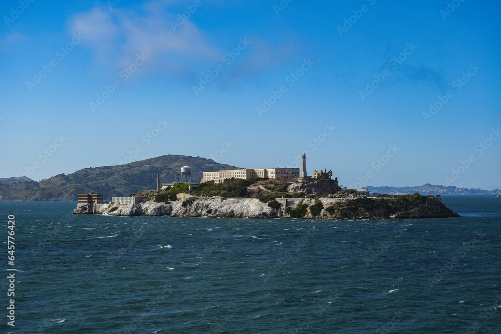 Alcatraz Island in San Francisco Bay seen from ship during Harbor Cruise from SFO tourist landmark travel destination on sunny day with clouds and blue sky
