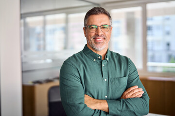 Smiling older bank manager or investor, happy middle aged business man boss ceo, confident mid adult professional businessman executive standing in office, mature entrepreneur headshot portrait.