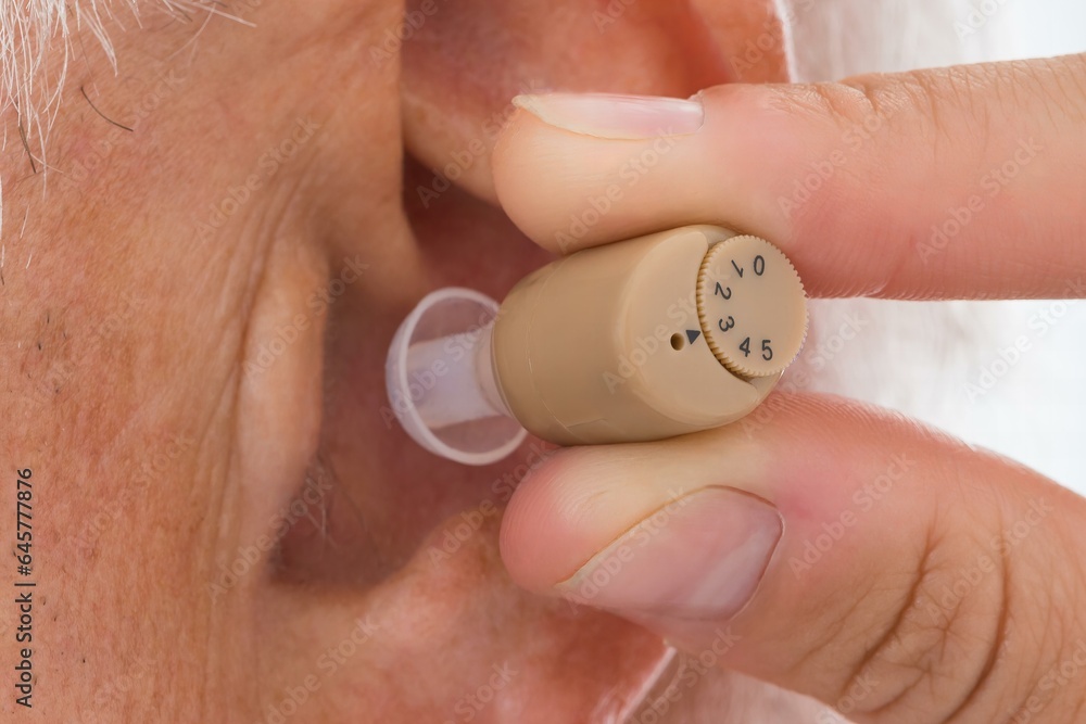 Fototapeta premium Doctor Putting Hearing Aid In Patient's Ear