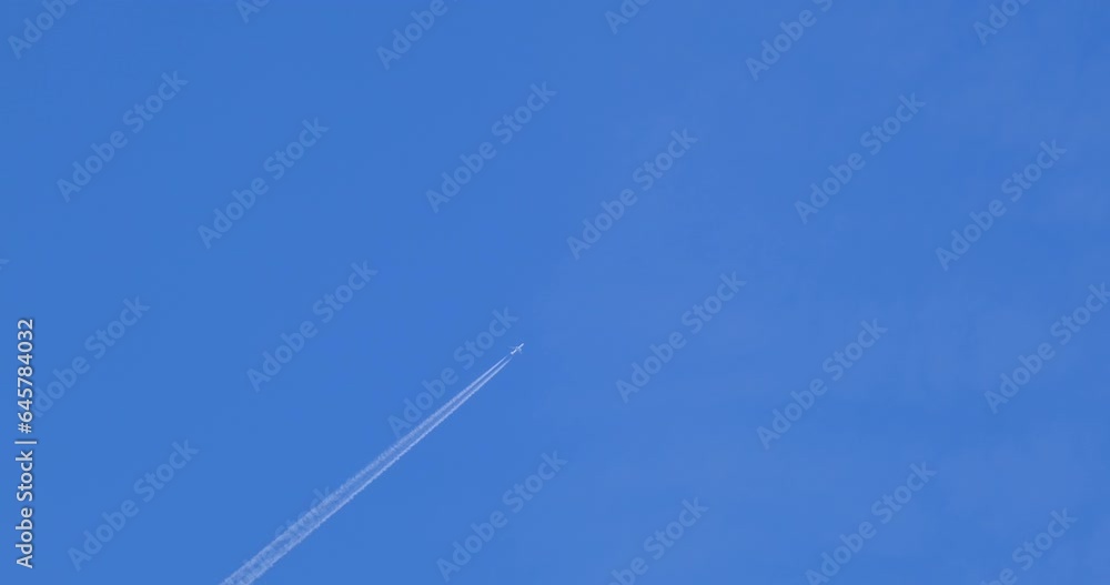 Airplane flying on deep blue sky with chemical direction trails Airplane flying on deep blue sky with chemical direction trails