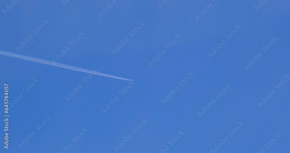 Airplane flying on deep blue sky with chemical direction trails Airplane flying on deep blue sky with chemical direction trails