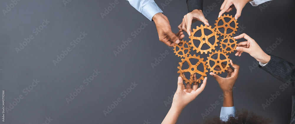 Panoramic shot top view of business people holding cog wheel as unity and teamwork in corporate workplace concept. Office worker colleague with symbol of visionary system for business success. Concord - obrazy, fototapety, plakaty 
