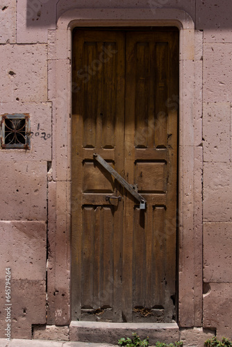 Puerta de madera en la fachada de una casa antigua en un pueblo de México.