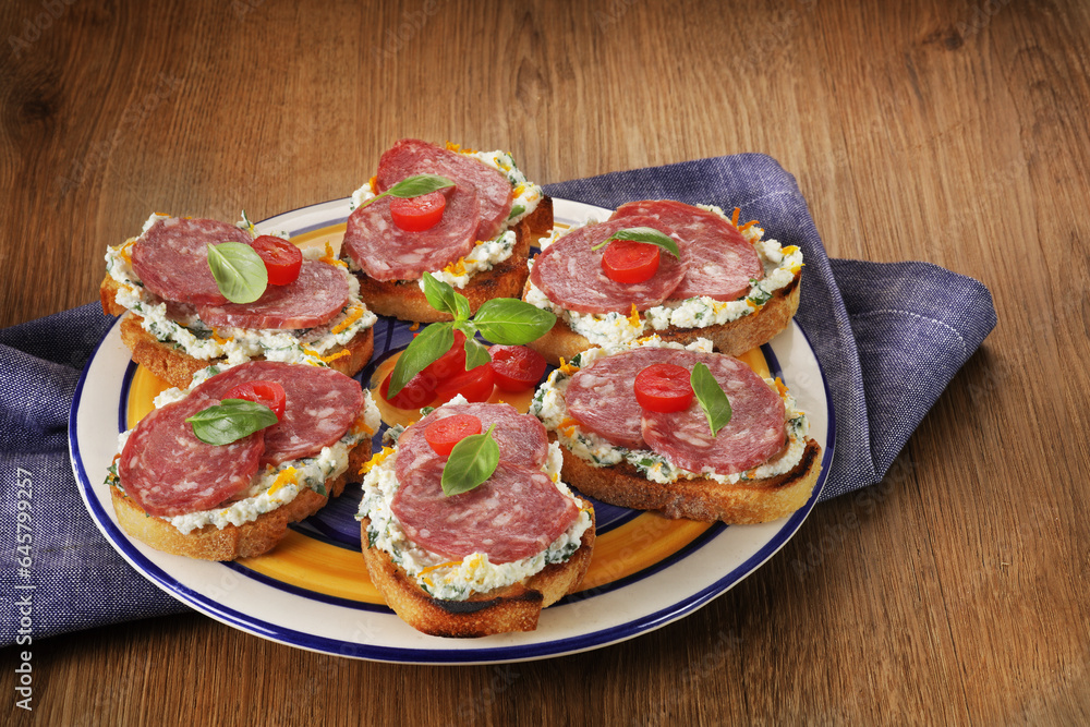 aperitivo de pao italiano com ricota e salsinha, raspas de laranja coberta com salame e tomete cereja aperitivo de pao italiano com ricota e salsinha, raspas de laranja coberta com salame e tomete cereja