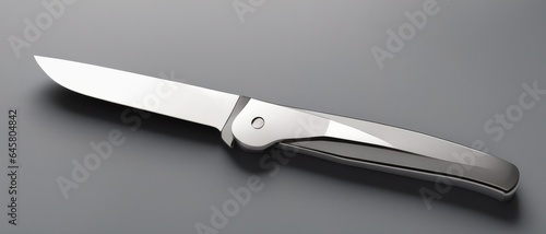 Close-up of a folding metal gray knife on a white surface