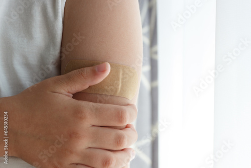 Arm with a plaster on the skin. Concept of vaccination and immunization