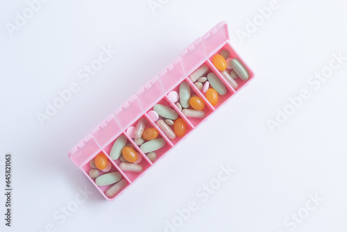 Obraz na płótnie Close-up of a pink pill organiser with medicine inside. w salonie