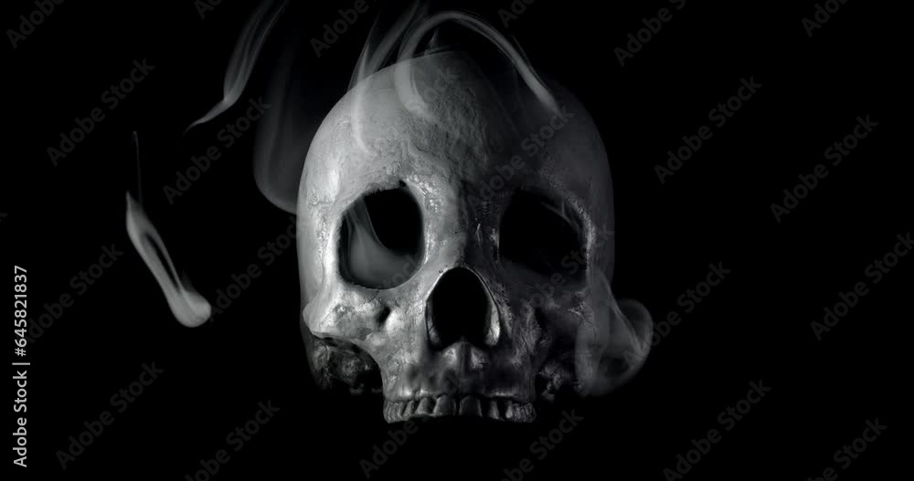 Smoke slowly creeping through the eye sockets of a terrifying human skull, haunted spirt, or frightening ghost for Halloween or other spooky scene. Smoke slowly creeping through the eye sockets of a terrifying human skull, haunted spirt, or frightening ghost for Halloween or other spooky scene.