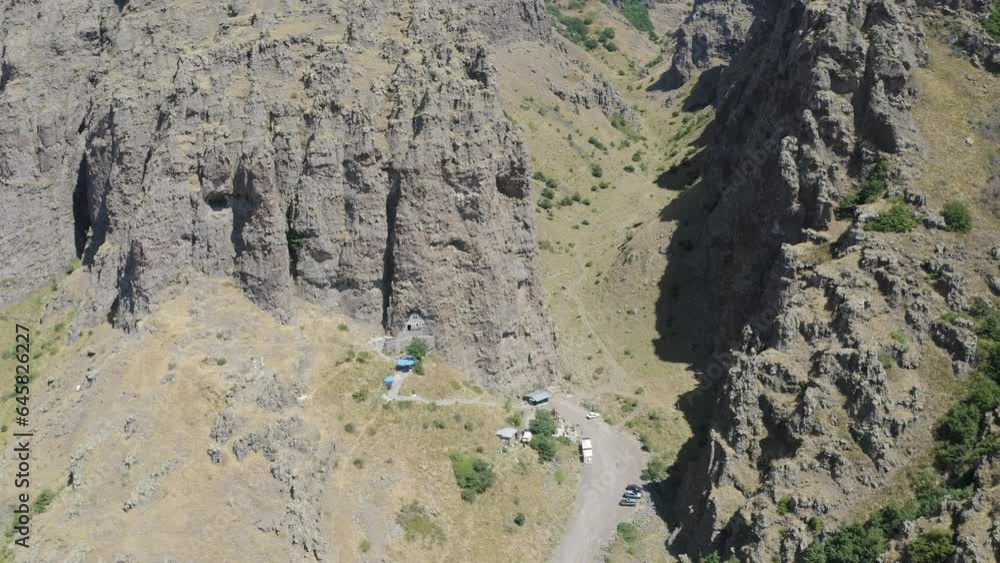 Forward reveal aerial shot of St. Barbara cave church on sunny summer day. Tsakhkevank monastery, Armenia. Forward reveal aerial shot of St. Barbara cave church on sunny summer day. Tsakhkevank monastery, Armenia.