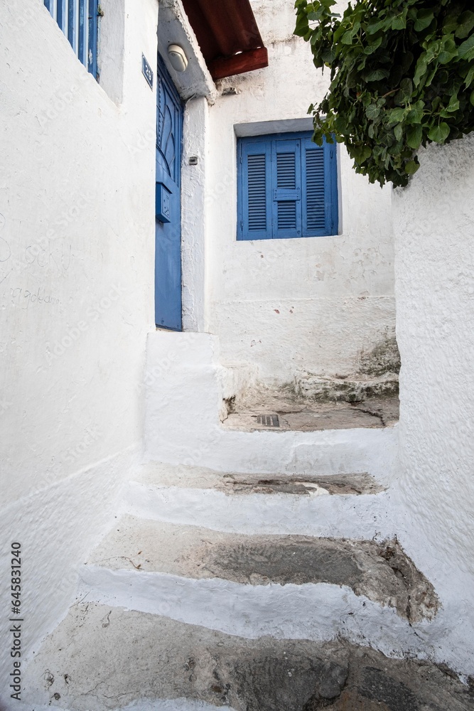 Narrow streets with blue wooden window in a cute district made of chalk in Plaka, Athens, Greece