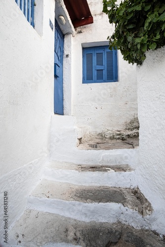 Narrow streets with blue wooden window in a cute district made of chalk in Plaka, Athens, Greece © jordieasy