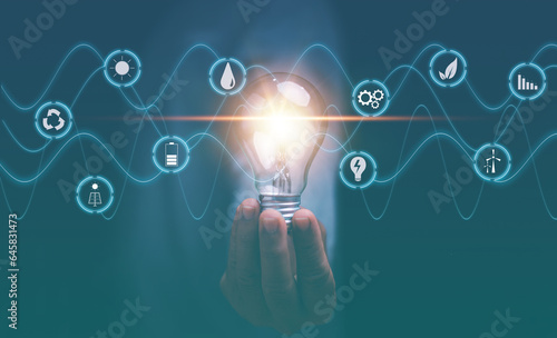 Creative ideas of saving energy and renewable power concept, New ideas for energy management, Hand holding glowing lightbulb with sine wave and energy icon, Saving investment, Inspiration.