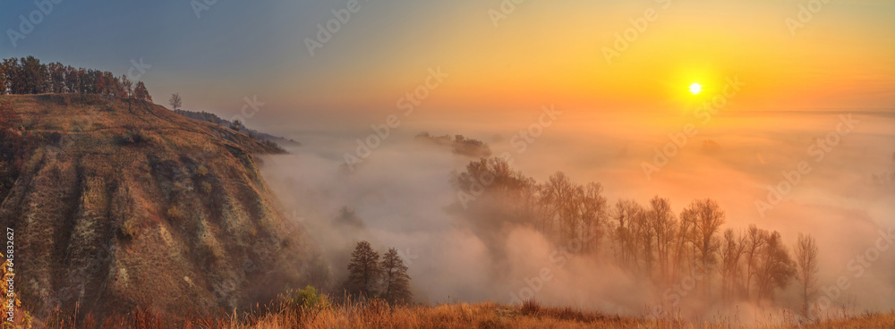 Autumn sunrise landscape, panorama, banner - view of a river valley covered with fog in the light of the sunrays, the northeast of Ukraine Autumn sunrise landscape, panorama, banner - view of a river valley covered with fog in the light of the sunrays, the northeast of Ukraine