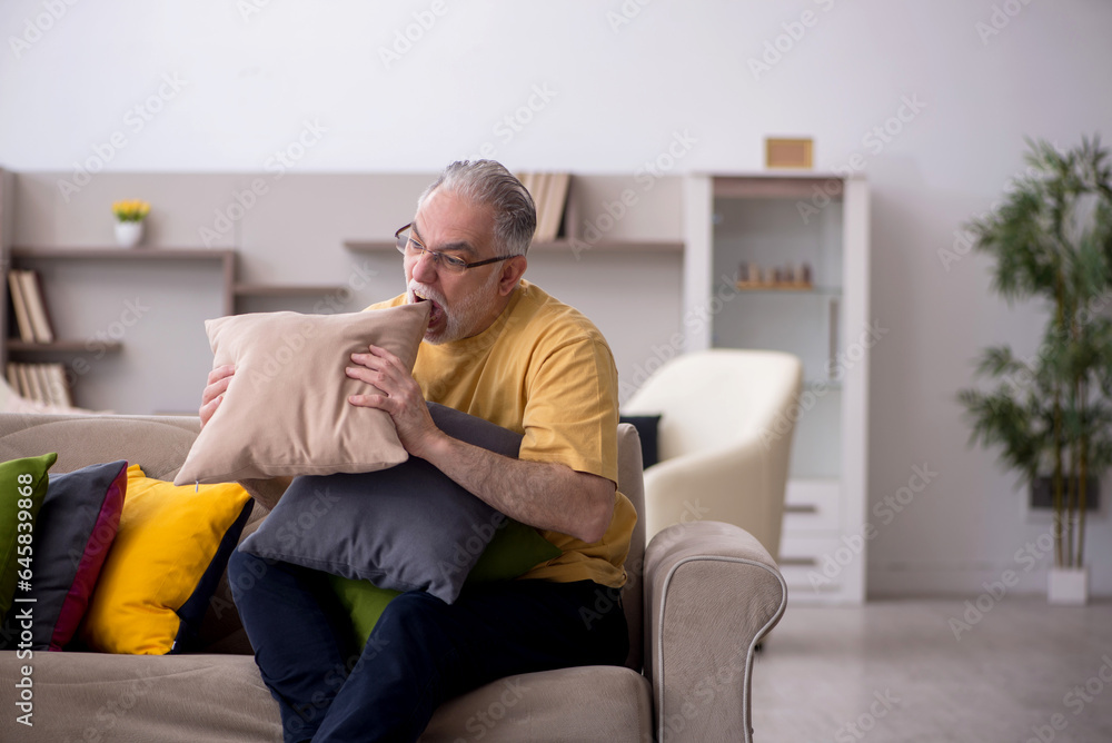 Old man with many pillows at home