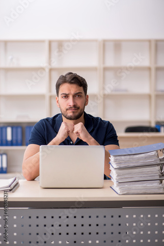 Young male employee sitting at workplace