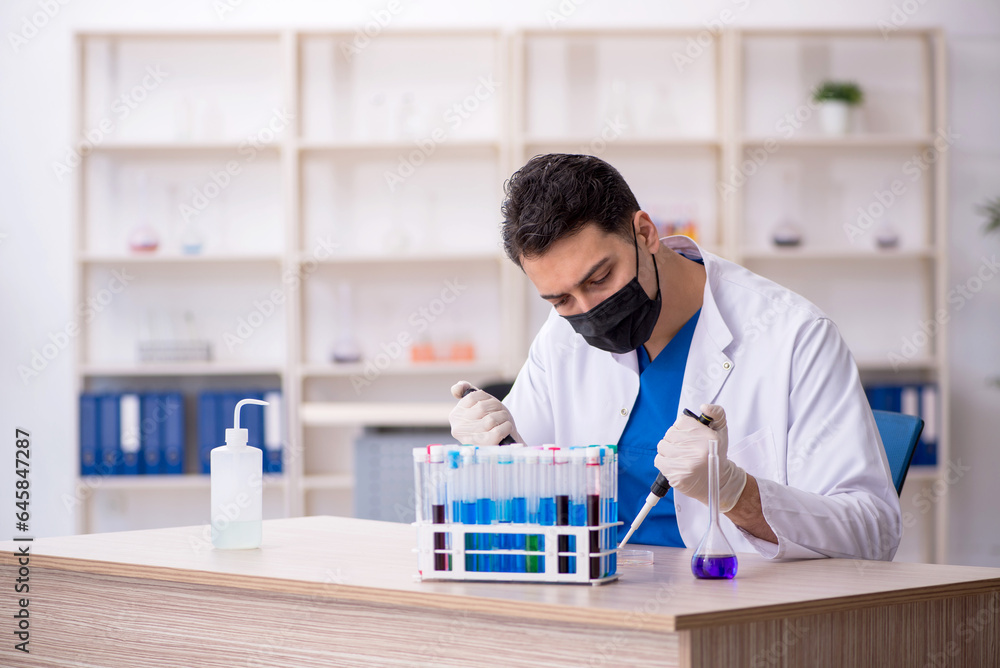 Young male chemist working at the lab Young male chemist working at the lab