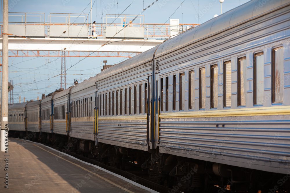 Obraz premium A long-distance passenger train made a stop in a small town, photographed in clear weather in summer, Ukraine.