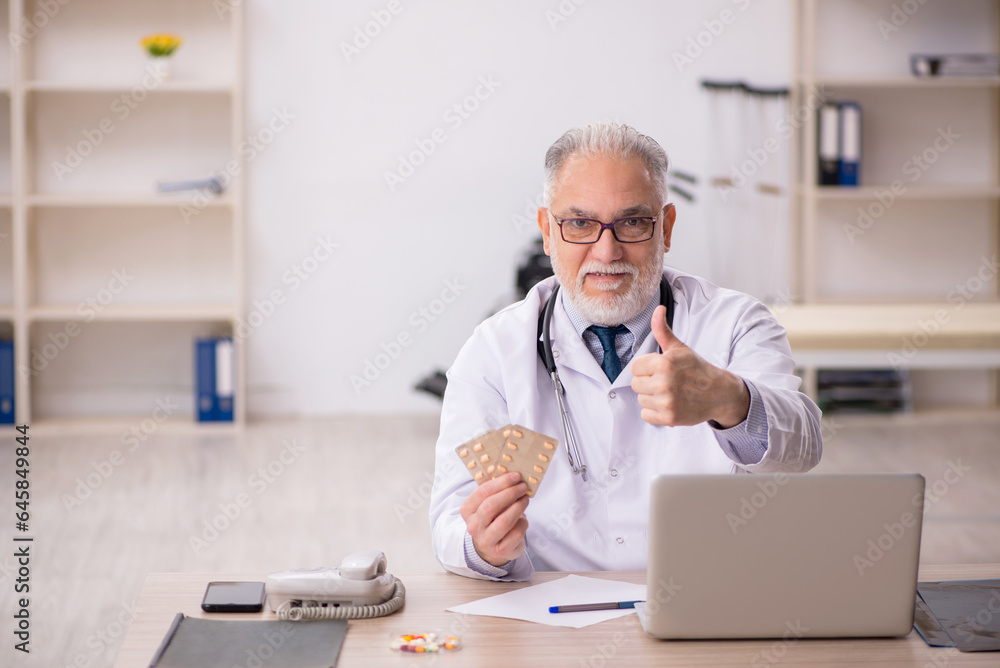 Old male doctor working in the clinic Old male doctor working in the clinic