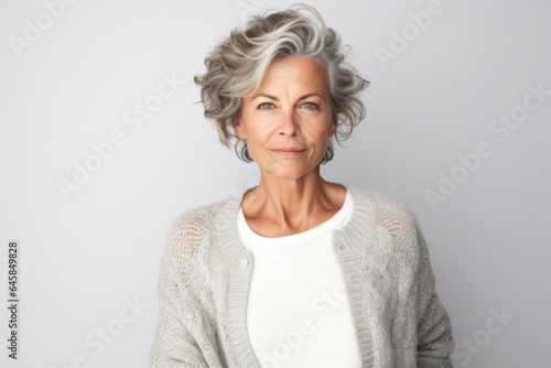 Portrait photography of a serious French woman in her 50s against a white background
